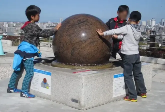 屋外広場にある「グラニットボール」。重さ約1トンの巨大な石が水の圧力で浮いているモニュメントで、ボールを触って回すこともできる