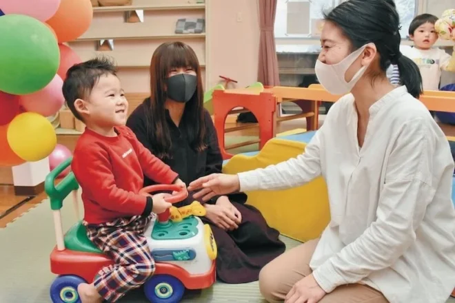 地域子育て支援センター「いずみ」で、母親（中央）の相談を受けながら、子どもと遊ぶ職員