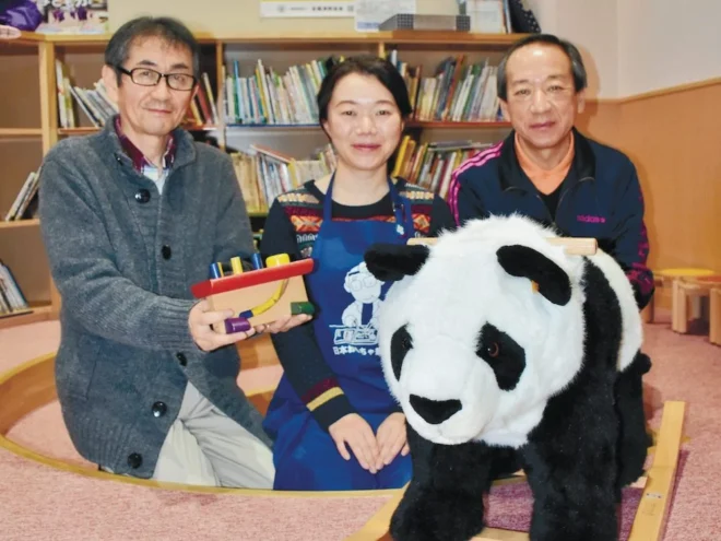 壊れたおもちゃを直した土田和世さん(中央)と、喜ぶ鉄南保育園の山口哲園長(左)、さくら保育園の福島孝洋園長