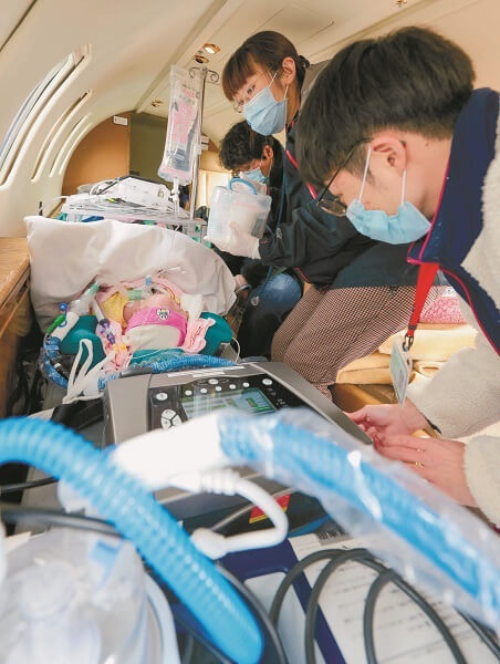 機内で赤ちゃんの人工呼吸器や点滴などを点検する医療者（大石祐希撮影）
