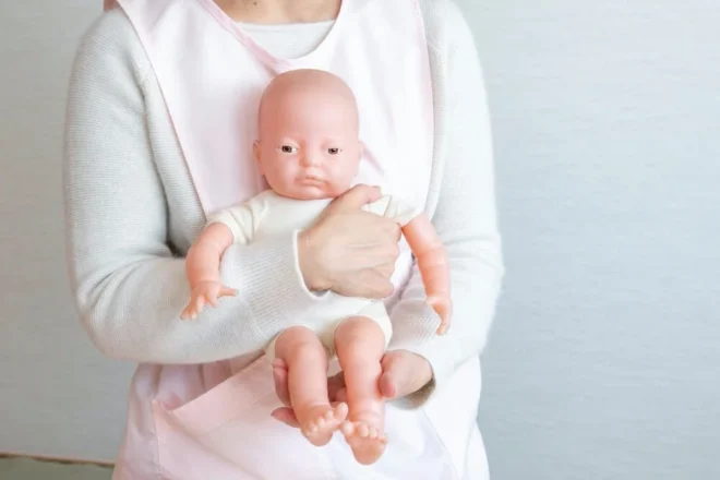 ローリング抱きの途中の手順。赤ちゃんの後頭部を自分の胸に密着させ、手でお尻を支える （「さっぽろ子育て情報サイト」から）