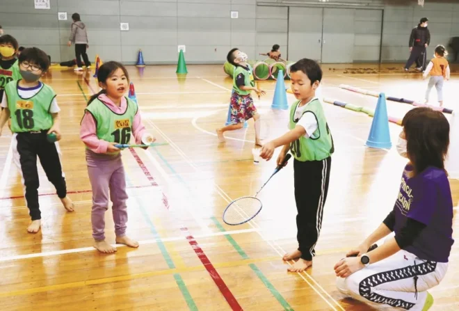 作田文子代表（右端）のサポートで、バドミントンの道具などを使った運動を楽しむ子どもたち