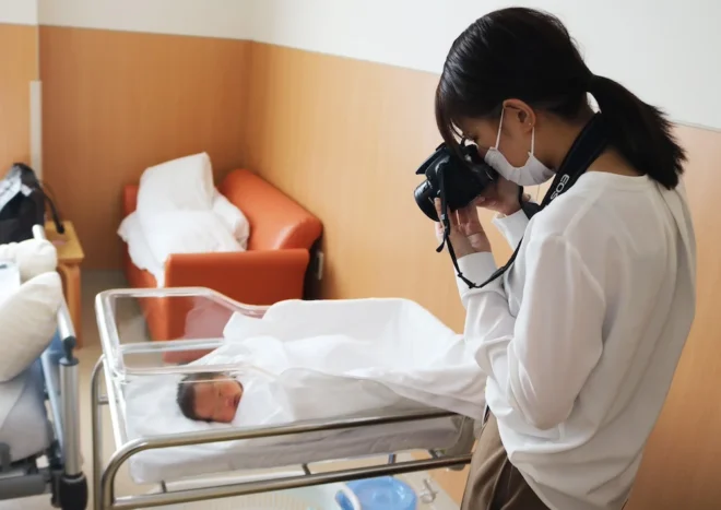 赤ちゃんの写真を撮影する明山さん（砂川市立病院提供）
