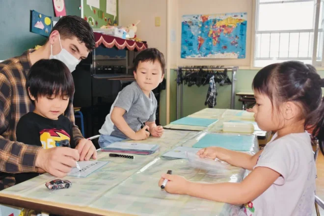英語教育に力を入れている「インターナショナル山の手幼稚園」。外国籍の教員に教わりながら、アルファベットで名前を書く練習をする園児たち