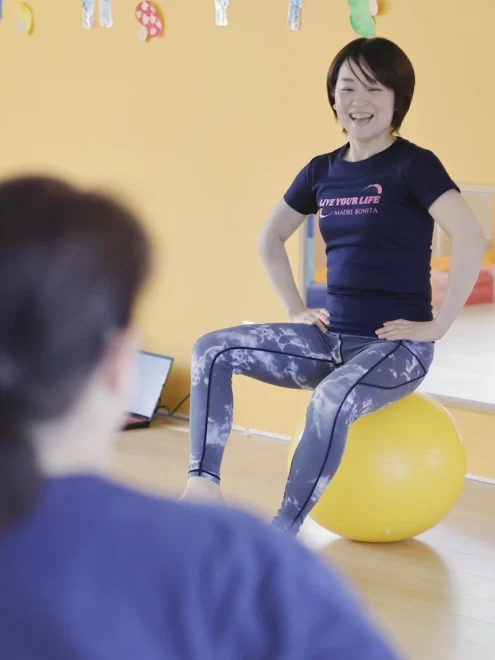 バランスボールで体を動かしながら、健康作りのアドバイスをする平野聡恵さん。自らの経験から子育て中の母親の力になりたいと教室を始めた＝12日（星野雄飛撮影）