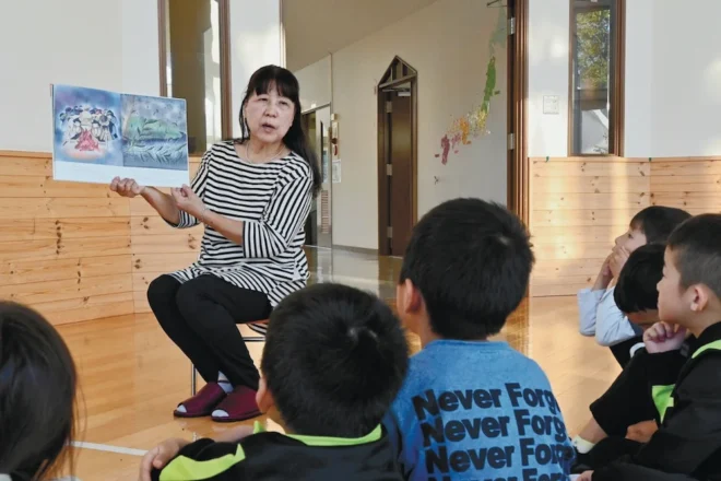 町内の児童館で読み聞かせを行う鍛冶恵子代表と、物語を楽しむ子どもたち