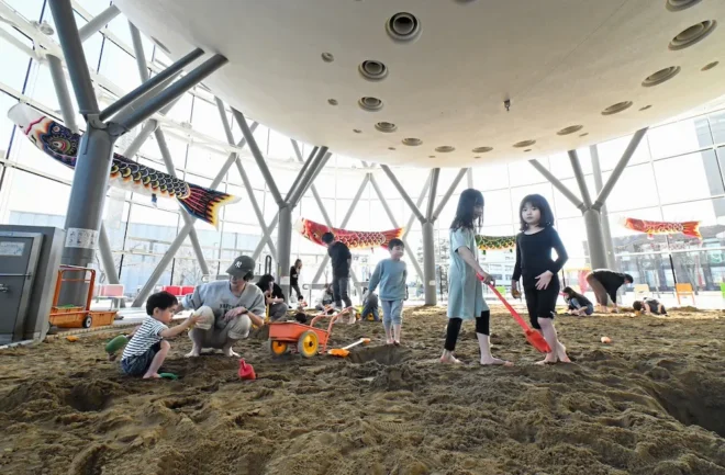 子どもたちが砂を掘ったり手押し車で運んだりして遊ぶ砂場。球形をした天井部分はプラネタリウムの下部だ（国政崇撮影）