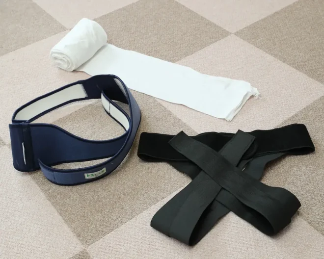 腰痛対策のために使う骨盤用のベルト（手前右と左）と腹帯（奥）＝中村祐子撮影
