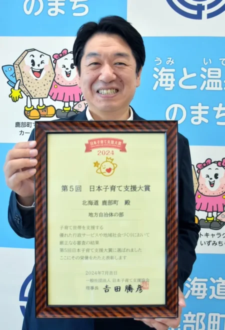 日本子育て支援大賞の賞状を手にする盛田昌彦町長