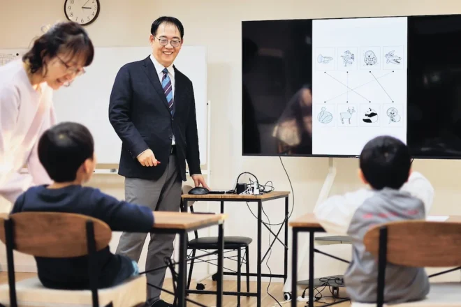模擬テストの後、問題の解説を聞きながら答え合わせをする子どもたち(玉田順一撮影)