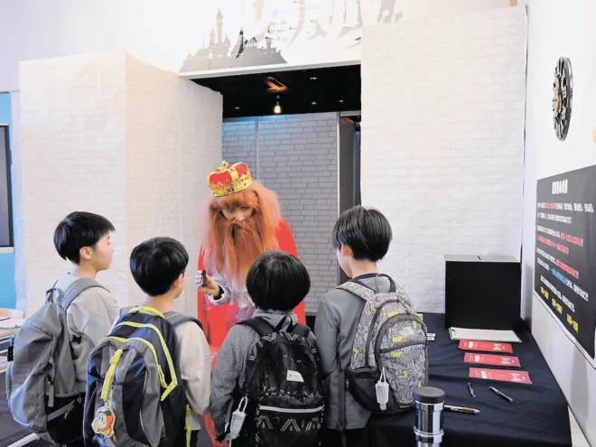 企画展の迷路「ルミナス城」の入り口で、王様姿で子どもたちにルールを説明するスタッフ